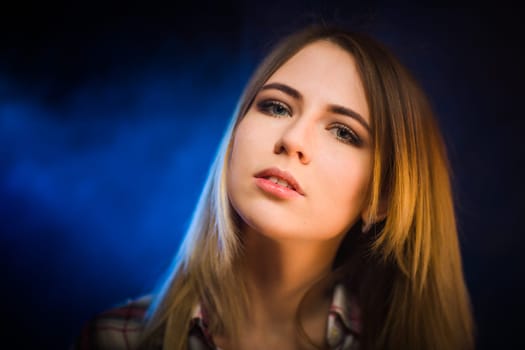 portrait smiling girl on blue background in studio.