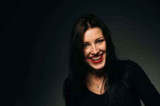 emotional girl smiling on a dark background.