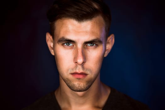 Portrait of a young man on a dark background.