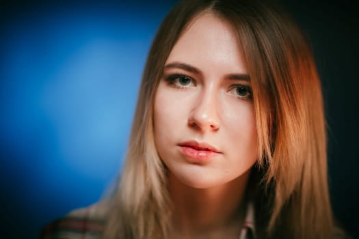 portrait smiling girl on blue background in studio.