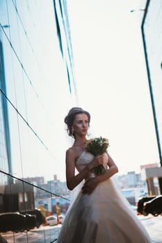 Bride and bouquet on backround mirror buildings