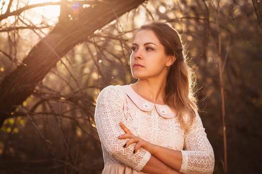 portrait of a girl in a field on a sunset background.