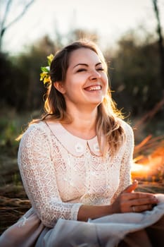 girl is sitting in the field on the sunset background.