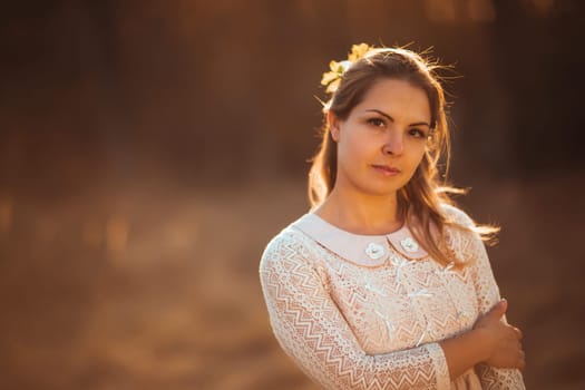 portrait of a girl in a field on a sunset background.