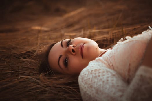 portrait of a girl lying on a field on a sunset background.