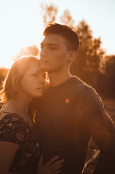 guy and girl in the field on the sunset background.