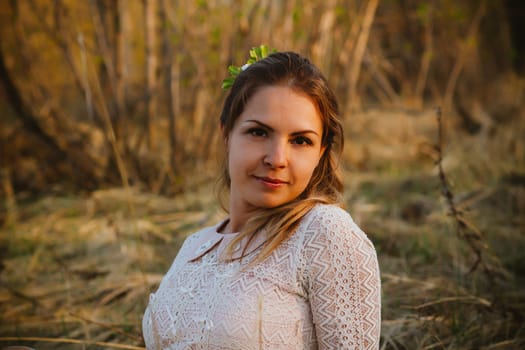 girl is sitting in the field on the sunset background.