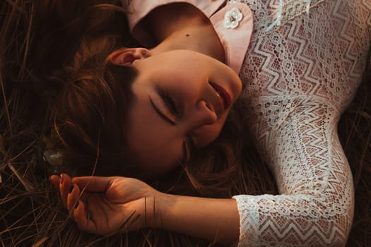 portrait of a girl lying on a field on a sunset background.