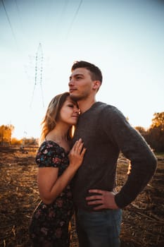 guy and girl in the field on the sunset background.