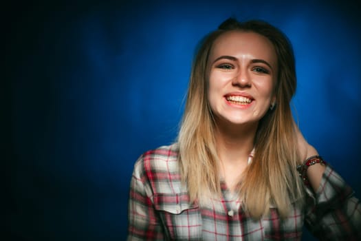 portrait smiling girl on blue background in studio.