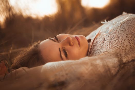 portrait of a girl lying on a field on a sunset background.