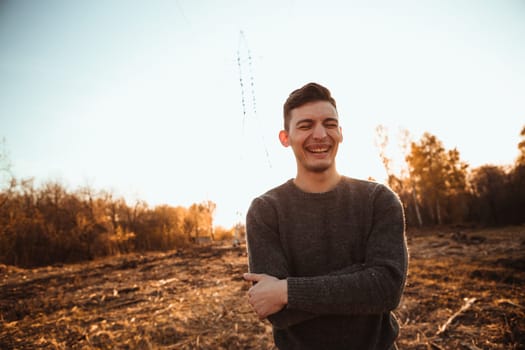 portrait of a guy in the field on a sunset background.