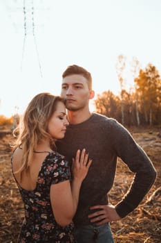 guy and girl in the field on the sunset background.