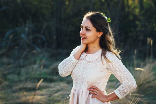 portrait of a girl in a field on a sunset background.