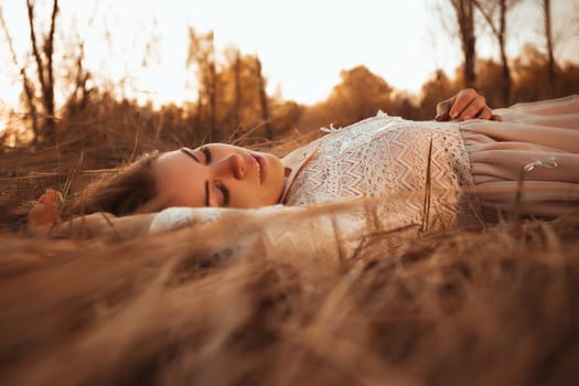 girl lying on the field on a sunset background.