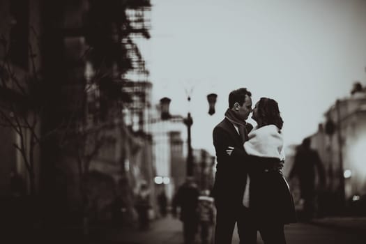 Black white photo couple on the background of the street in lanterns.