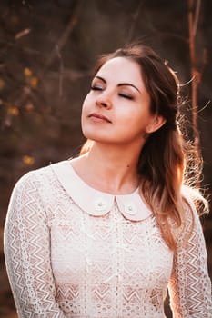 portrait of a girl in a field on a sunset background.
