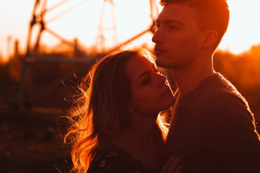 guy and girl in the field on the sunset background.