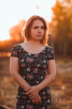portrait of a beautiful girl in a field on a sunset background.