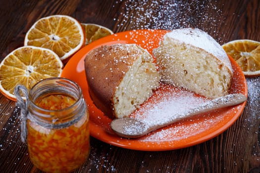 Slices of cake in a plate on a wooden table with a jar of candied orange