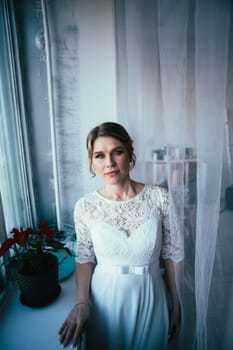 portrait of a bride near a window studio.
