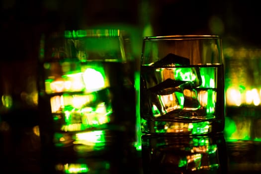 colored lighting of glasses in the night club bar.