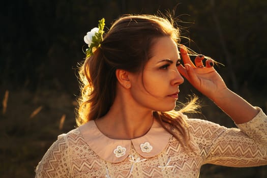 portrait of a girl in a field on a sunset background.