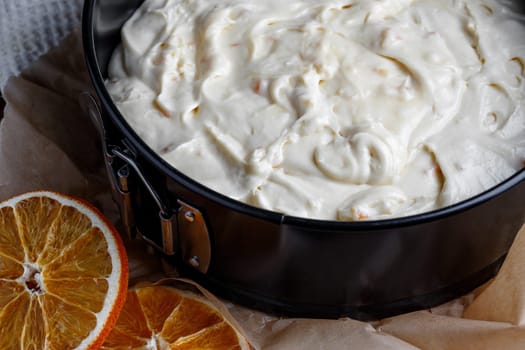 Cake dough with candied orange in a baking sheet
