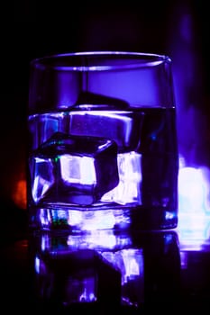 colored lighting of glasses in the night club bar.