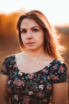 portrait of a beautiful girl in a field on a sunset background.