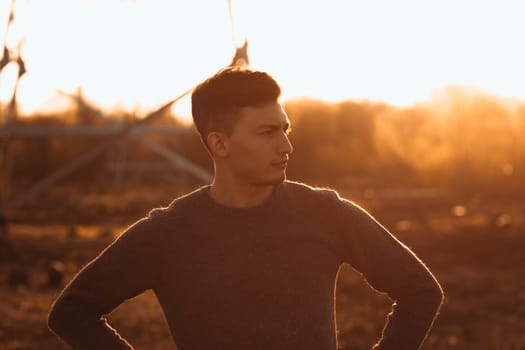 portrait of a guy in the field on a sunset background.