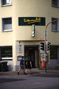 Koblenz, Germany - April 08, 2018: Pedestrians pass the corner entrance of the bar and the restaurant Frankenschänke with advertising signs on 08 April 2018 in Koblenz..