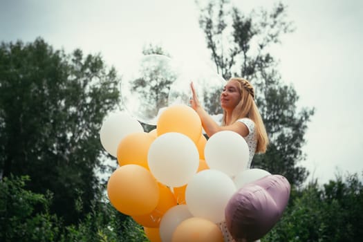 young girl with balloons on nature background.