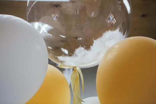 Festive balloons close up with white ostrich feather.