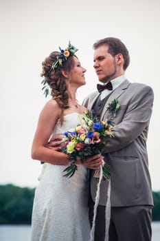 young couple in the style of provence on background of river.