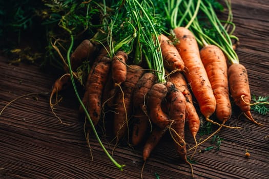 Fresh carrots from the garden close-up on a wooden background.