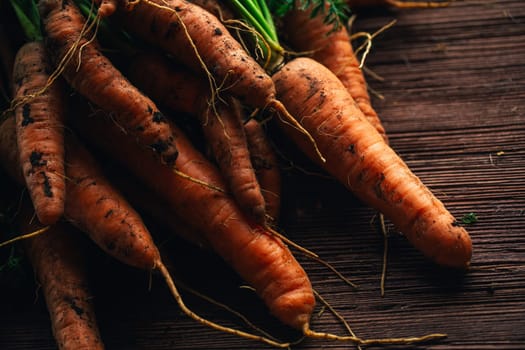 Fresh carrots from the garden close-up on a wooden background.