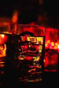 colored lighting of glasses in the night club bar.