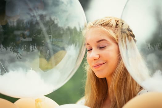 portrait of young girl with balloons on nature background.