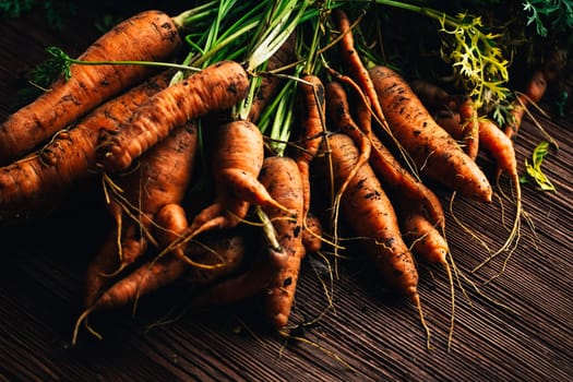 Fresh carrots from the garden close-up on a wooden background.