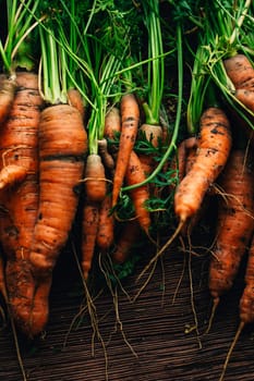 Fresh carrots close-up on a wooden background.