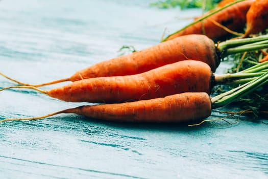 lot of carrots on a wooden background.
