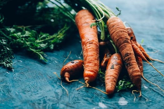 Fresh carrots on a blue wooden background.