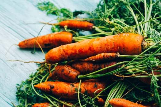 lot of carrots on a wooden background.