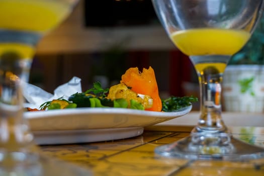 Plate with salmon salad and orange juice. Lunch in cafe Liepkalni, Latvia. Dinner in cafe.