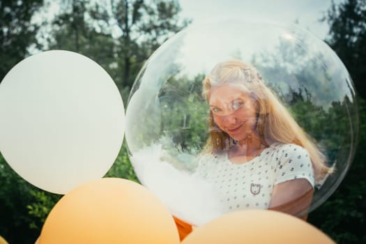 portrait of young girl with balloons on nature background.