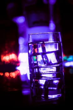 colored lighting of glasses in the night club bar.