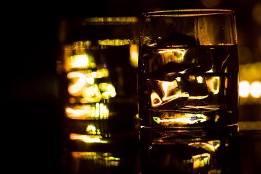 colored lighting of glasses in the night club bar.