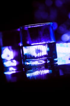 colored lighting of glasses in the night club bar.