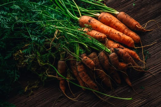 Fresh carrots from the garden close-up on a wooden background.